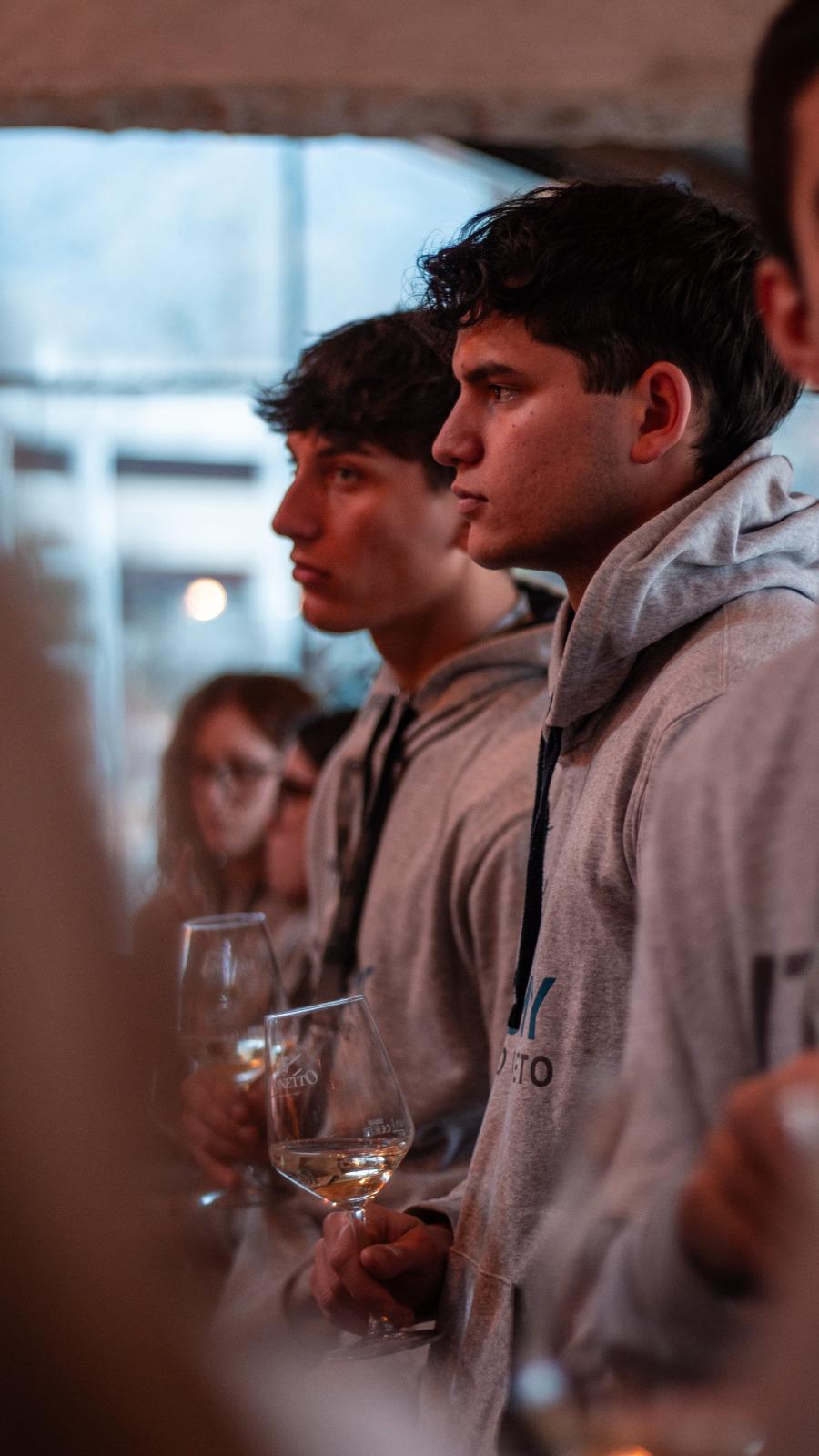 ragazzi con un bicchiere di vino in mano