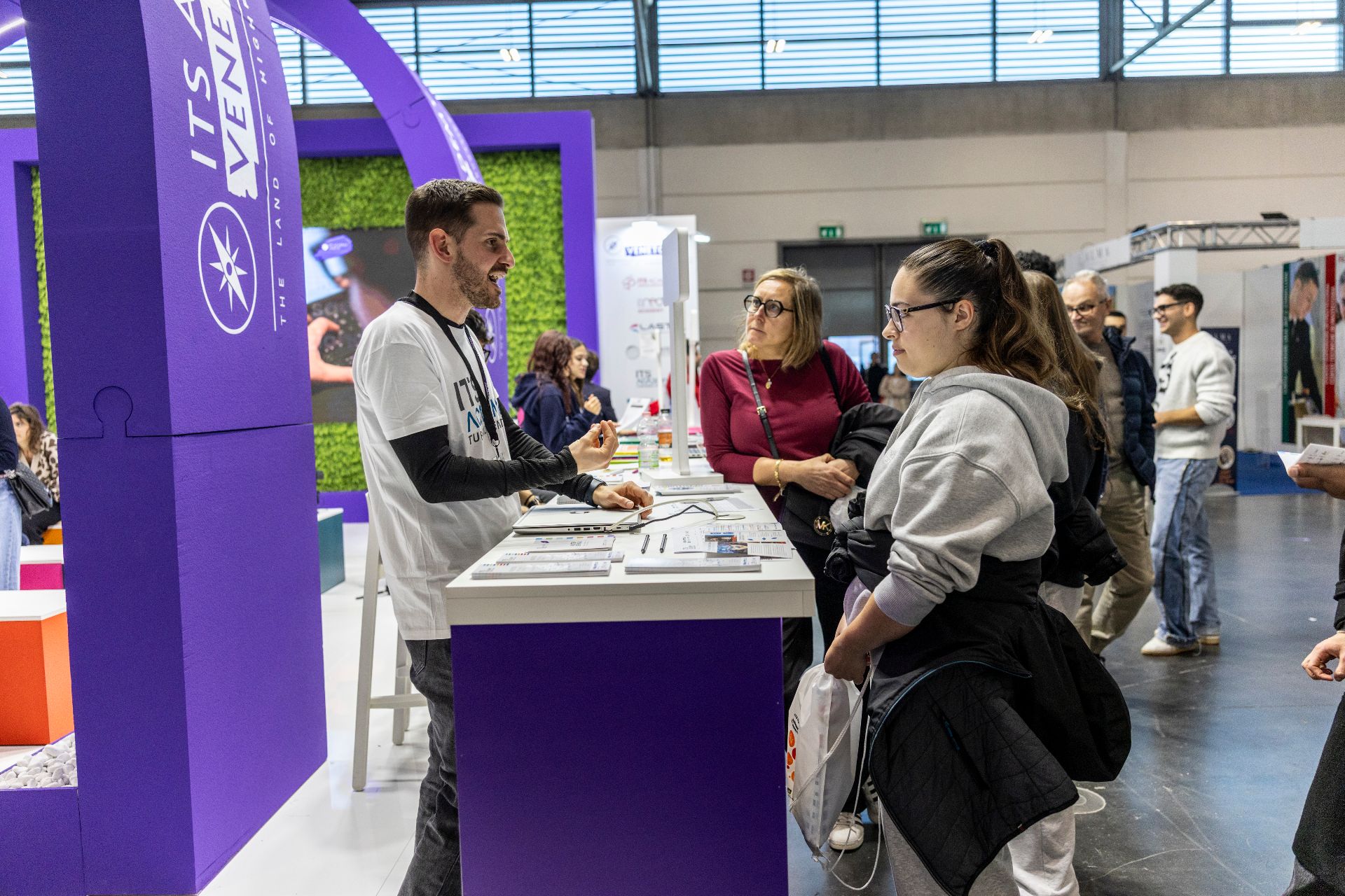 stand di una fiera con persone che parlano